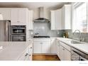 Well-lit kitchen featuring stainless steel appliances, subway tile backsplash, and white cabinetry at 2879 Shadow Lake Rd, Lafayette, CO 80026