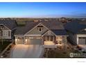 Charming home featuring a well-manicured lawn, stone accents, and a welcoming two-car garage at 2882 Heron Lakes Pkwy, Berthoud, CO 80513