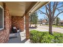 Inviting covered front porch with brick columns, offering a charming outdoor seating area at 3124 Marlin Dr, Longmont, CO 80503