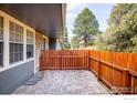 Fenced stone patio and garden space with mature shade trees visible at 3823 Paseo Del Prado, Boulder, CO 80301