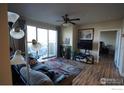 Inviting living room featuring a sliding glass door to a balcony and a ceiling fan at 4500 Baseline Rd # 4104, Boulder, CO 80303