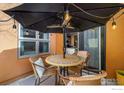Inviting patio area featuring an umbrella, outdoor lighting, and comfortable seating at 801 Confidence Dr # 2, Longmont, CO 80504