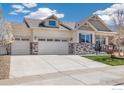 Beautiful home exterior featuring a spacious three-car garage and decorative stone accents at 8962 Foxfire St, Firestone, CO 80504