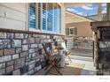 Inviting front porch seating area with stylish chairs, a decorative rug, and stone detailing at 8962 Foxfire St, Firestone, CO 80504