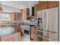 Well-appointed kitchen boasts stainless steel appliances, custom cabinetry, and a stylish tile backsplash at 918 E 132Nd Ave, Thornton, CO 80241