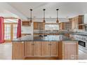 Bright kitchen features wooden cabinets, granite counters, large island and stainless steel appliances at 918 E 132Nd Ave, Thornton, CO 80241