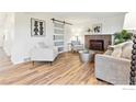 Cozy living room with a brick fireplace and modern furnishings at 11833 W Marlowe Pl, Morrison, CO 80465