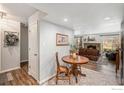 Cozy dining area with a round wooden table, leading to the living room with a fireplace at 1226 Atwood St, Longmont, CO 80501