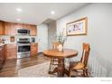 Cozy kitchen with wood cabinets and stainless steel appliances featuring a breakfast nook with dining table set at 1226 Atwood St, Longmont, CO 80501