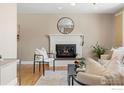 Cozy fireplace featuring brick accents, complemented by stylish décor and hardwood floors at 1315 Brookfield Dr, Longmont, CO 80501