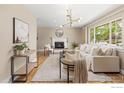 Bright living room with hardwood floors, a fireplace, and a large window at 1315 Brookfield Dr, Longmont, CO 80501