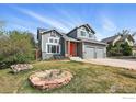 Two-story house with gray siding, orange door, two-car garage, and well-maintained lawn at 1528 Alpine St, Longmont, CO 80504