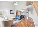 A bright living room featuring hardwood floors, high ceilings, and a view into the dining area at 1528 Alpine St, Longmont, CO 80504