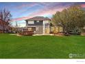 Spacious backyard with well-maintained lawn, mature trees, and a charming patio area at 2066 Ridgeview Way, Longmont, CO 80504