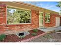 Lovely brick home showcasing a mature tree and a cozy front entrance with a charming garden at 2511 Brentwood St, Lakewood, CO 80214