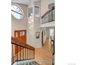 Bright entryway with soaring ceilings, modern light fixture, and wooden staircase with metal railings at 3333 E Florida Ave # 129, Denver, CO 80210