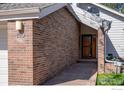 Exterior brick detail with walkway leading to the front door and a view of the house number at 3333 E Florida Ave # 129, Denver, CO 80210