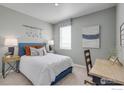 Cozy bedroom featuring a blue bed frame, stylish desk, and soft natural lighting at 4202 Sandstone Dr, Mead, CO 80504