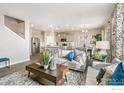 Bright living room featuring modern decor, neutral furniture, and open-concept design to kitchen at 4202 Sandstone Dr, Mead, CO 80504