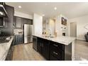 Modern kitchen island featuring dark cabinets, granite countertops, a sink, and stainless steel appliances at 452 Wagon Bend Rd, Berthoud, CO 80513