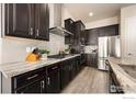 Well-equipped kitchen with dark cabinets, stainless steel appliances, granite countertops, and light gray backsplash tiles at 452 Wagon Bend Rd, Berthoud, CO 80513