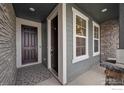 Inviting front entryway showcasing stone details, a gray wood door, and sidelight windows at 583 Olive St, Broomfield, CO 80023