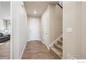 Bright entryway features wood floors, a staircase, and a white front door at 583 Olive St, Broomfield, CO 80023