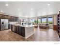 Open-concept living room with wood floors, a large island, and views of the dining area and backyard at 583 Olive St, Broomfield, CO 80023