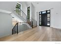 Bright entryway with hardwood floors, large windows, and a staircase with modern black metal railings at 640 Iris Ave, Boulder, CO 80304