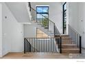 Staircase with hardwood steps, black metal railing, and white walls with plentiful natural light at 640 Iris Ave, Boulder, CO 80304