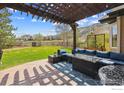 Inviting backyard patio with pergola, comfortable seating, fire pit, and views of open space at 726 Mourning Dove Ln, Golden, CO 80401