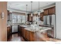 Spacious kitchen with stainless steel appliances, granite countertops, dark wood cabinets and an island at 869 Bluestem Ln, Louisville, CO 80027