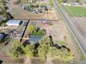 Aerial view of house on a lot with a yard, barn, and gardens at 9951 Sierra Vista Rd, Longmont, CO 80504