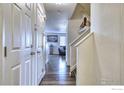 Hallway with hardwood floors and access to multiple rooms on the first floor at 10635 E 96Th Pl, Commerce City, CO 80022