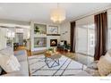 Open-concept living space offers a fireplace, sliding glass door, and hardwood floors at 14215 Waterside Ln, Broomfield, CO 80023