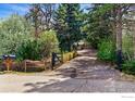 A long driveway leads to a house surrounded by lush landscaping and mature trees at 182 Ridge Rd, Boulder, CO 80303
