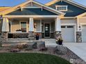 Inviting covered front porch with stone accents and landscaped garden at 1916 High Plains Dr, Longmont, CO 80503