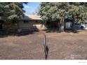 Well-kept brick home surrounded by mature trees and a nicely landscaped front yard at 2071 W 54Th Pl, Denver, CO 80221
