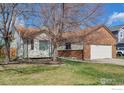 Attractive one-story home featuring a brick facade, two-car garage, and lush front lawn at 2131 Kay St, Longmont, CO 80501