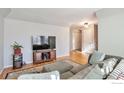 Comfortable living room with hardwood floors and neutral decor, adjacent to entryway and staircase at 2131 Kay St, Longmont, CO 80501