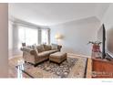 Cozy living room features large bay window, neutral color palette, and hardwood floors at 2131 Kay St, Longmont, CO 80501