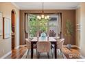 Elegant dining room featuring hardwood floors, a chandelier, and a large window with outdoor views at 2353 S Juniper Way, Lakewood, CO 80228