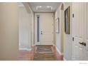 Inviting foyer with warm wood floors, arched doorways, and a stylish front door with sidelight at 2353 S Juniper Way, Lakewood, CO 80228