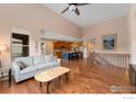 Open-concept living room boasts hardwood floors, high ceilings and seamless flow to kitchen and staircase at 2353 S Juniper Way, Lakewood, CO 80228
