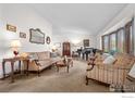 Formal living room with vintage furniture, natural light from bay window, and a grand piano at 2417 15Th Ave, Longmont, CO 80503