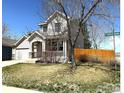 A charming two-story home with a front porch, lawn and a shade tree at 2432 Tyrrhenian Dr, Longmont, CO 80504