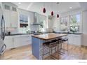 Modern kitchen boasts white cabinetry, stainless steel appliances, and a central island with bar seating at 3021 Jefferson St, Boulder, CO 80304
