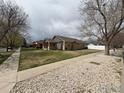 A neighborhood view showing the home's placement with a well-kept lawn and tree-lined street at 318 E Iowa Ave, Berthoud, CO 80513