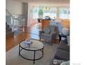 Open living room with hardwood floors, bright windows, and a view into the dining area at 322 W Harper St, Louisville, CO 80027