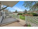 Cozy front porch with wood deck, white lattice fence, and green landscaping at 3390 34Th St # B, Boulder, CO 80301